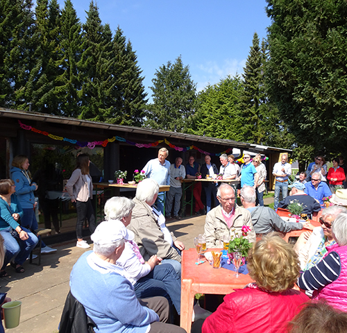 Viele menschen, die im Sommer vor dem Clubhaus der Tennisfreunde Ahrensfelde e.V. an Tischen sitzen.