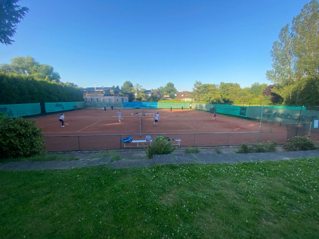 Ein Tennisplatz mit vier Männern, die ein Match spielen.
